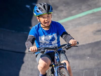 Child riding a bicycle and wearing a helmet