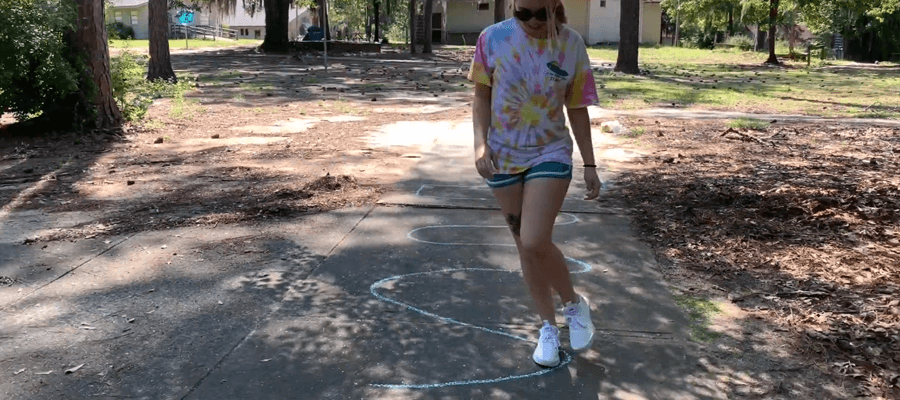 Person walking down sidewalk while holding chalk image