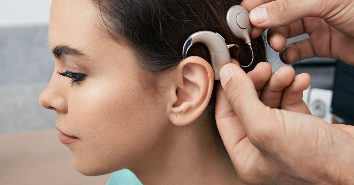 Young girl with brown hair being fit with a cochlear implant