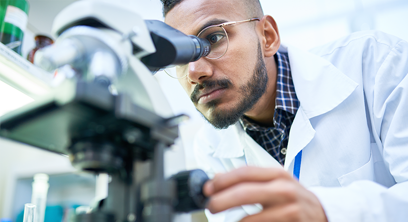 doctor looking into microscope