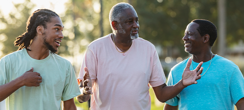 Three African American men walking and talking animatedly together