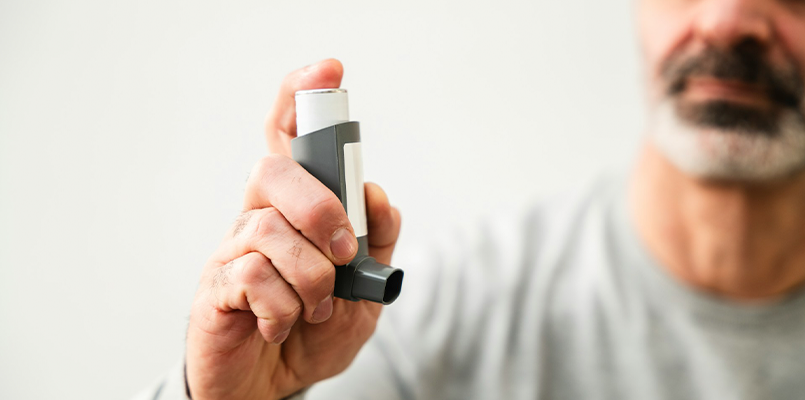 man holding inhaler up to camera.