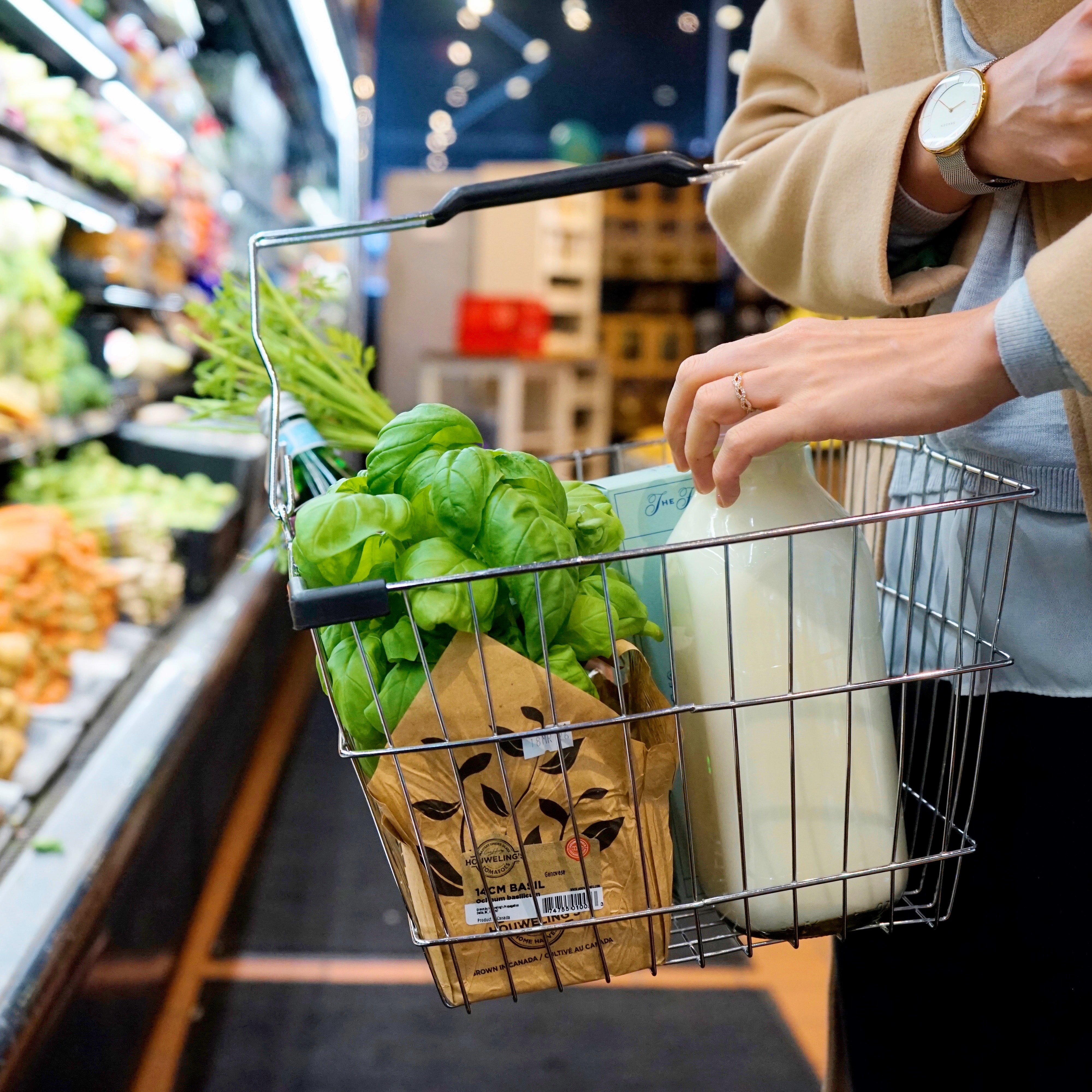 woman standing in front of produce at the grovery store