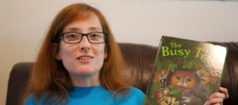 Woman holding the book "The Busy Tree" image