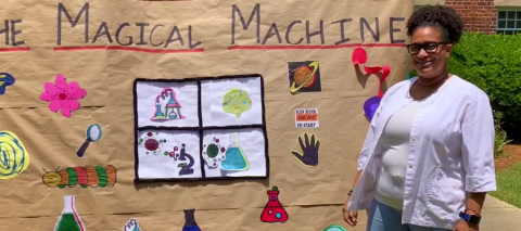 Woman standing in front of "Magical Machine" board image