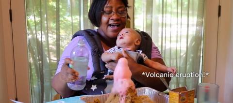 Woman holding a baby with a DIY volcano image