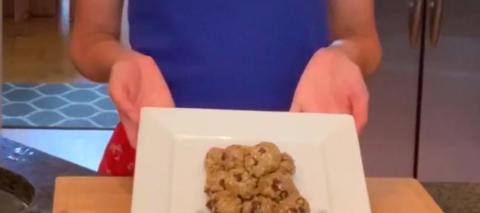 Person holding a cookie on a plate