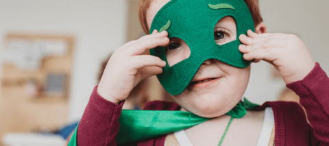 child holding green felt mask over face